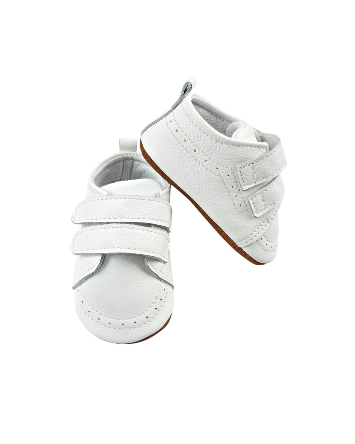 Zapatos bebé primeros pasos de cuero blanco con doble velcro, vista lateral sobre fondo neutro