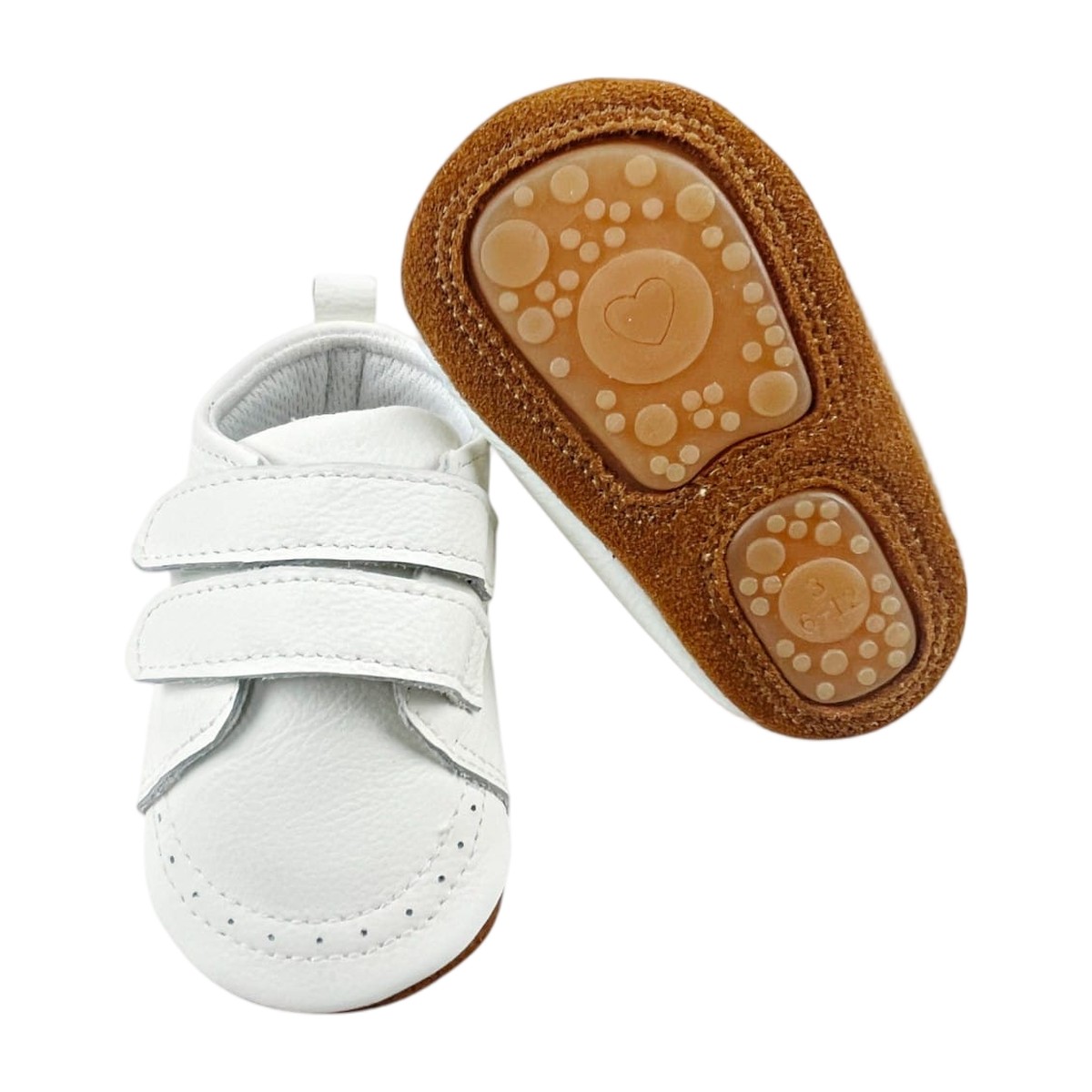 Zapatos bebé de cuero blanco ultraflexibles, mostrando la forma ergonómica de la suela