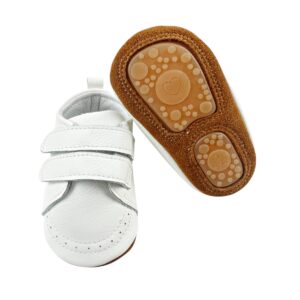 Zapatos bebé de cuero blanco ultraflexibles, mostrando la forma ergonómica de la suela