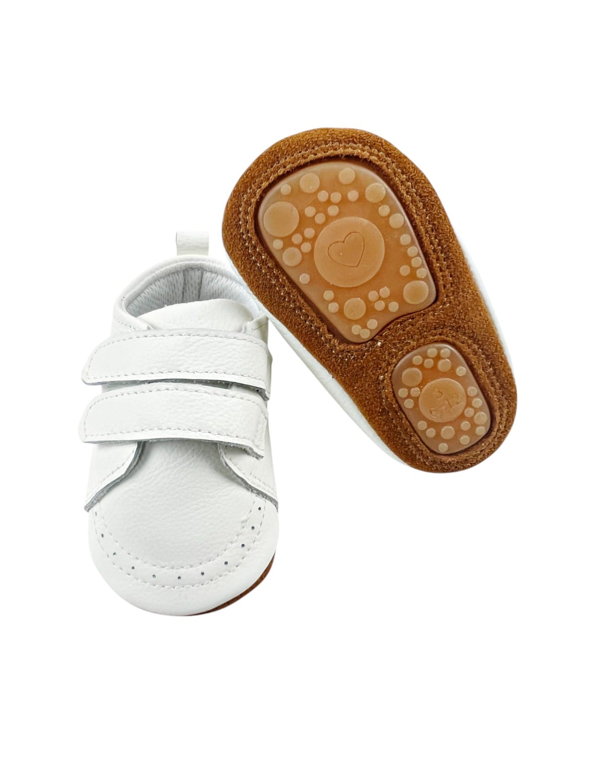 Zapatos bebé de cuero blanco ultraflexibles, mostrando la forma ergonómica de la suela