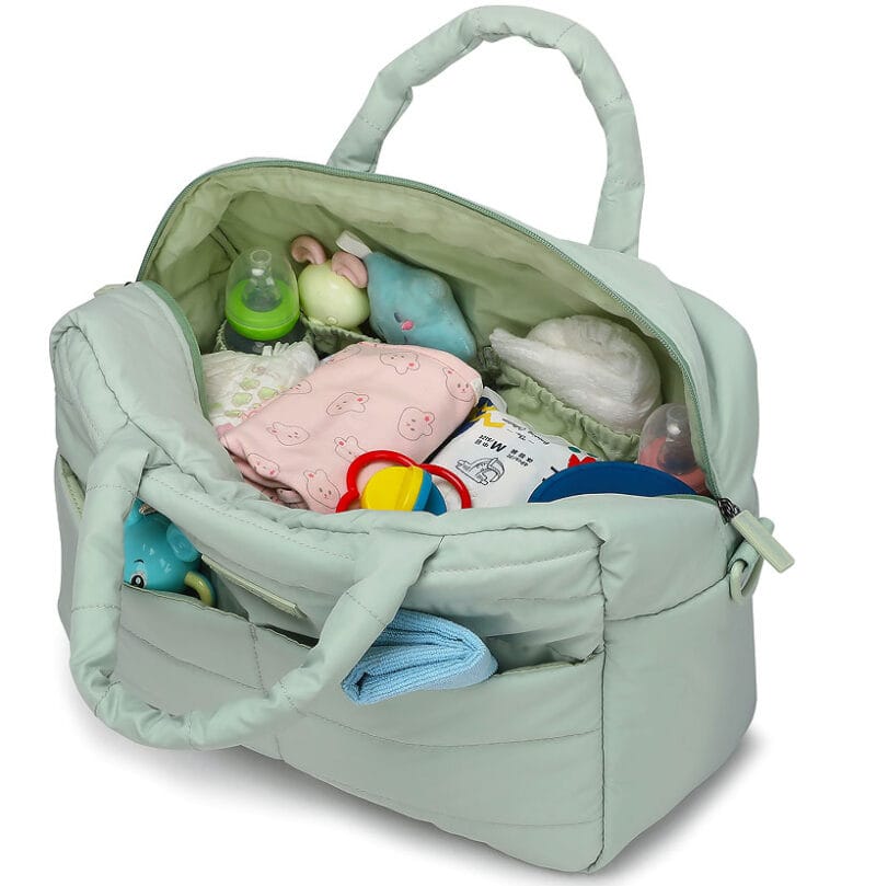Interior amplio del bolso maternal con pañales, ropa y juguetes organizados