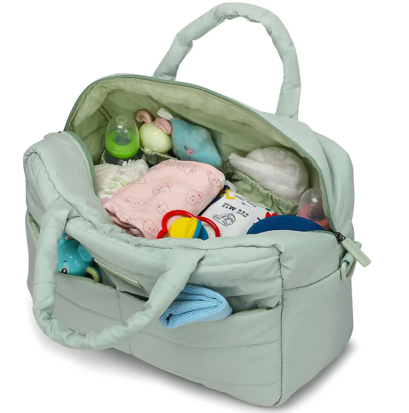 Interior amplio del bolso maternal con pañales, ropa y juguetes organizados