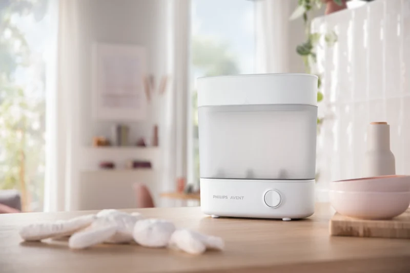 Esterilizador Philips Avent compacto sobre mesón blanco, diseño minimalista